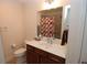 A well-lit bathroom with a wood vanity, a white countertop, and a shower-tub combo at 1000 Silver Summit Se Dr, Conyers, GA 30094