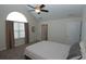 This bedroom features a ceiling fan, a large arched window, and neutral carpet and walls at 1000 Silver Summit Se Dr, Conyers, GA 30094