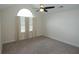Bright bedroom with an arched window, neutral carpet, and a ceiling fan providing lots of natural light at 1000 Silver Summit Se Dr, Conyers, GA 30094