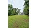 Spacious backyard with green lawn and home with a wooden deck in the background at 49 Patty Dr, Dallas, GA 30157