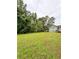 Spacious backyard with lush green lawn and view of back of house and wooden deck at 49 Patty Dr, Dallas, GA 30157