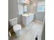 Bathroom featuring toilet and vanity with white cabinets, drawers and neutral tile flooring at 49 Patty Dr, Dallas, GA 30157