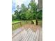 Spacious wooden deck overlooking a lush backyard with mature trees and foliage at 49 Patty Dr, Dallas, GA 30157
