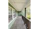 Covered porch with painted wood flooring, green siding, and black trim at 49 Patty Dr, Dallas, GA 30157