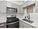 Modern kitchen featuring gray cabinets, quartz countertops, stainless steel appliances, and updated lighting at 100 Biscayne Nw Dr # C1, Atlanta, GA 30309