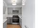 Well-equipped kitchen featuring stainless steel appliances, sleek gray cabinetry, and modern lighting fixtures at 100 Biscayne Nw Dr # C1, Atlanta, GA 30309