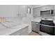 Modern kitchen featuring gray cabinets, quartz countertops, stainless steel appliances, and updated lighting at 100 Biscayne Nw Dr # C1, Atlanta, GA 30309