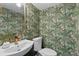 Stylish powder room featuring vibrant botanical wallpaper, a modern sink, and elegant fixtures at 100 Biscayne Nw Dr # C1, Atlanta, GA 30309