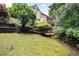 A spacious backyard featuring a lush lawn, landscaping, and a view of the home's exterior at 2613 Winterthur Main Nw, Kennesaw, GA 30144