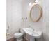 Half bathroom features a pedestal sink, a mirror, and floral wallpaper at 2613 Winterthur Main Nw, Kennesaw, GA 30144