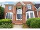 Close-up of a classic brick home with a striking front door and manicured greenery at 2613 Winterthur Main Nw, Kennesaw, GA 30144