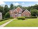 Beautiful two-story brick home featuring a well-manicured lawn and mature landscaping at 2613 Winterthur Main Nw, Kennesaw, GA 30144