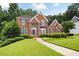 Charming brick home with a lush green lawn, complemented by neatly trimmed shrubs and trees at 2613 Winterthur Main Nw, Kennesaw, GA 30144