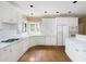 Bright kitchen features recessed lighting, white cabinetry, hardwood floors, and stainless steel appliances at 2613 Winterthur Main Nw, Kennesaw, GA 30144