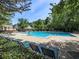 Large outdoor pool area with lounge chairs and surrounding trees, perfect for summer relaxation at 2613 Winterthur Main Nw, Kennesaw, GA 30144