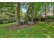A picturesque backyard featuring a shed, bench, picnic table, and mature trees, ideal for outdoor enjoyment at 1501 Memory Se Ln, Smyrna, GA 30080
