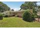 A tranquil backyard setting featuring lush green grass, mature trees, and a partial view of the home's exterior at 1501 Memory Se Ln, Smyrna, GA 30080