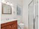 Bathroom featuring wood vanity, mirror, toilet, window, and glass enclosed shower at 1501 Memory Se Ln, Smyrna, GA 30080