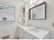 Bright bathroom featuring a white vanity, a large mirror, built-in shelves, and a window at 1501 Memory Se Ln, Smyrna, GA 30080