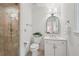 Bathroom showcasing a glass shower, toilet, vanity with an arched mirror, and tile flooring at 1501 Memory Se Ln, Smyrna, GA 30080