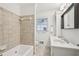 Well-lit bathroom featuring a vanity, soaking tub with tile surround and a tiled floor at 1501 Memory Se Ln, Smyrna, GA 30080