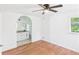 A bedroom with wood-look floors, ceiling fan, closet, and open door with a view to the bathroom at 2203 Second Ave, Decatur, GA 30032