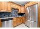 Kitchen with stainless steel appliances, stone backsplash, and light wood cabinetry with wine glass storage at 3071 Lenox Ne Rd # 19, Atlanta, GA 30324