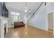 Open living room with hardwood floors, a cozy fireplace, and direct access to the staircase and upper level at 5013 Centennial Commons Nw Dr, Acworth, GA 30102