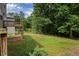 Lawn view of back of house featuring a deck, grassy lawn, and woods at 565 Lance View Ln, Lawrenceville, GA 30045