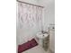 Bathroom featuring a toilet with a floral shower curtain and a plum colored floor mat at 565 Lance View Ln, Lawrenceville, GA 30045