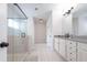 Bright bathroom with white cabinetry, gray countertops, and a glass-enclosed shower at 565 Lance View Ln, Lawrenceville, GA 30045