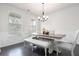 Elegant dining room with dark wood floors, wainscoting, and modern chandelier lighting at 565 Lance View Ln, Lawrenceville, GA 30045