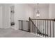 Hallway with a dark metal railing, chandelier, and a baby gate at the top of the stairs at 565 Lance View Ln, Lawrenceville, GA 30045