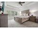 Main bedroom suite features a plush bed, ceiling fan, and a view out the window at 565 Lance View Ln, Lawrenceville, GA 30045