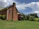 Well-maintained backyard featuring brick exterior, screen porch, mature trees, and lush lawn at 25 Darcee Ct, Lawrenceville, GA 30046