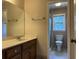 Bathroom featuring a tile shower, walk-in shower, and dark wooden cabinets at 25 Darcee Ct, Lawrenceville, GA 30046
