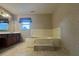 Bathroom featuring a large tub, dark wooden cabinets, and tile flooring at 25 Darcee Ct, Lawrenceville, GA 30046