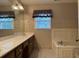 Bathroom featuring a large mirror, double sinks, bathtub, and decorative wallpaper at 25 Darcee Ct, Lawrenceville, GA 30046