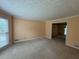 Spacious living room with neutral carpet, textured ceiling, and a large window at 25 Darcee Ct, Lawrenceville, GA 30046
