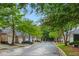 Street view showing the neighborhood's townhomes lined with lush trees at 3300 Suttles Sw Dr, Atlanta, GA 30331