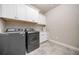 Well-organized laundry room with front load washer/dryer, white cabinets, and granite countertop at 406 Mareeba Park # 61, Canton, GA 30114