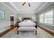 Well-lit main bedroom with ensuite bath access featuring a tray ceiling, ceiling fan, and hardwood floors at 406 Mareeba Park # 61, Canton, GA 30114