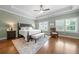 Main bedroom with a large bed, tray ceiling, wood floors, natural light from windows, and a ceiling fan at 406 Mareeba Park # 61, Canton, GA 30114