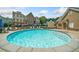 Community pool with lounge chairs, umbrellas and buildings in the background at 406 Mareeba Park # 61, Canton, GA 30114