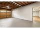 Unfinished basement with exposed wood ceiling, concrete floor, and access to the garage at 251 Waller Nw Cir, Marietta, GA 30064