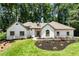 Charming white brick home features manicured landscaping and a lush green lawn at 251 Waller Nw Cir, Marietta, GA 30064
