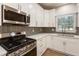 A modern kitchen featuring stainless steel appliances and gray backsplash at 251 Waller Nw Cir, Marietta, GA 30064