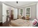 Bright bedroom with dark wood floors, soft colors, and an open door to a bonus area at 2638 Clairmont Rd, Atlanta, GA 30329