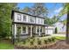 Charming two-story modern farmhouse with black trim, front porch, white siding and a beautifully landscaped front yard at 2638 Clairmont Rd, Atlanta, GA 30329