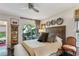 Comfortable bedroom featuring a ceiling fan, seating, and a balcony overlooking trees at 275 13Th Ne St # 201, Atlanta, GA 30309